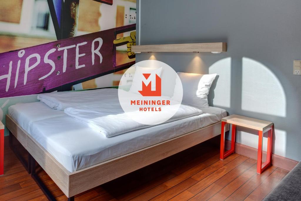 ein Bett in einem Zimmer mit einem Schild darauf in der Unterkunft Urban House Copenhagen by MEININGER in Kopenhagen