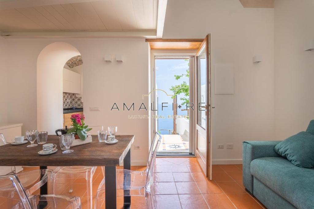 sala de estar con mesa y sofá azul en Lionetti Suite House en Amalfi