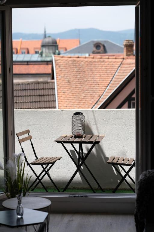 une table et deux chaises assises sur un balcon dans l'établissement MAMA with aircon including a parking space at 300 meters, à Colmar
