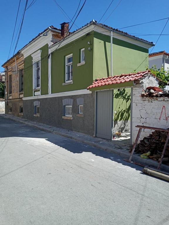 un edificio verde sul lato di una strada di Green Housee a Korçë