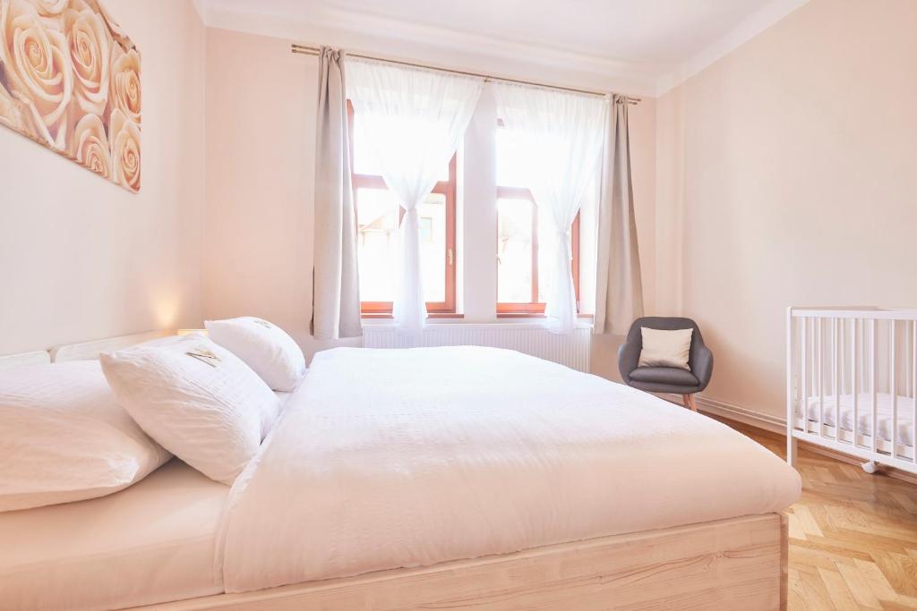 a white bedroom with a bed and a window at Wellness Penzion U Muzea in Liberec