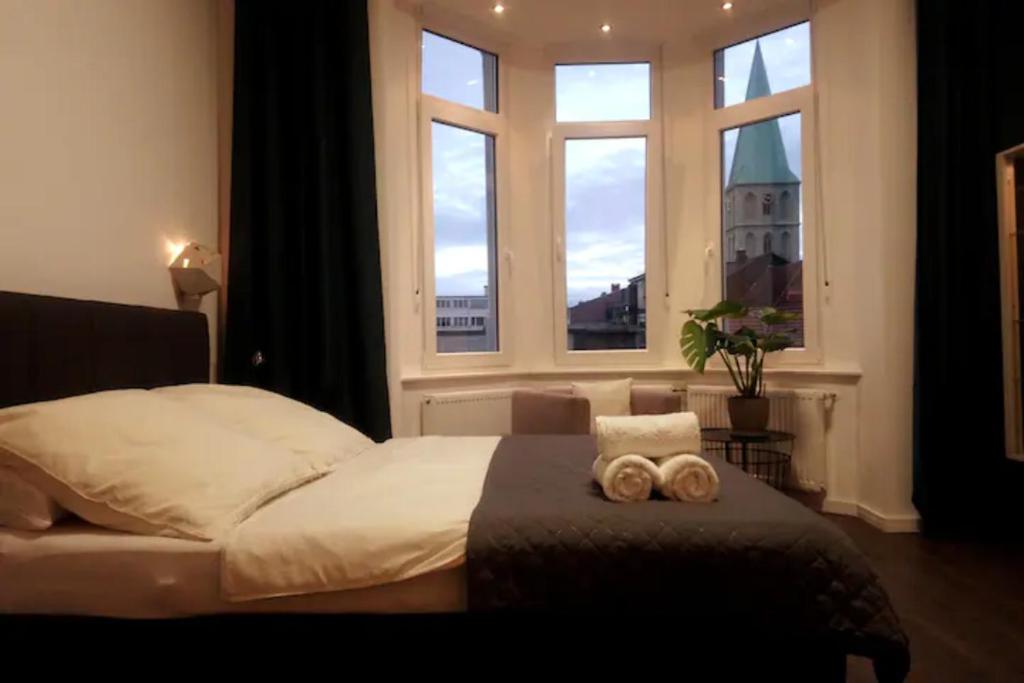 a bedroom with a bed with two towels on it at Diamera Appartments Zentral und Modern in Hamm