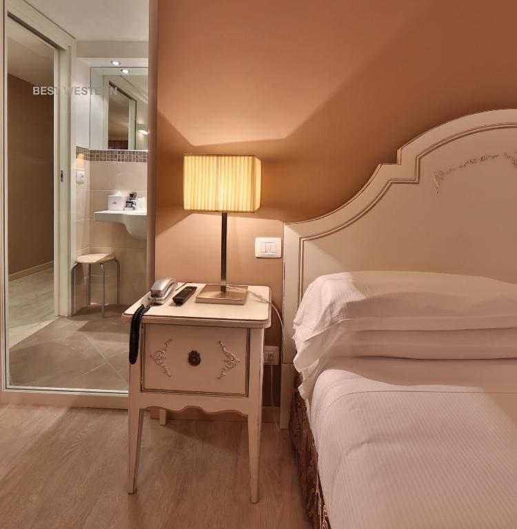 Postel nebo postele na pokoji v ubytování Hotel Canon d'Oro