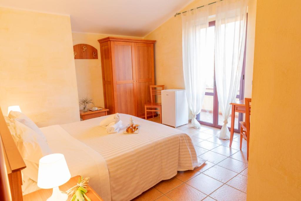 a bedroom with a white bed with two cats on it at Mediterraneo B&B in Pizzo