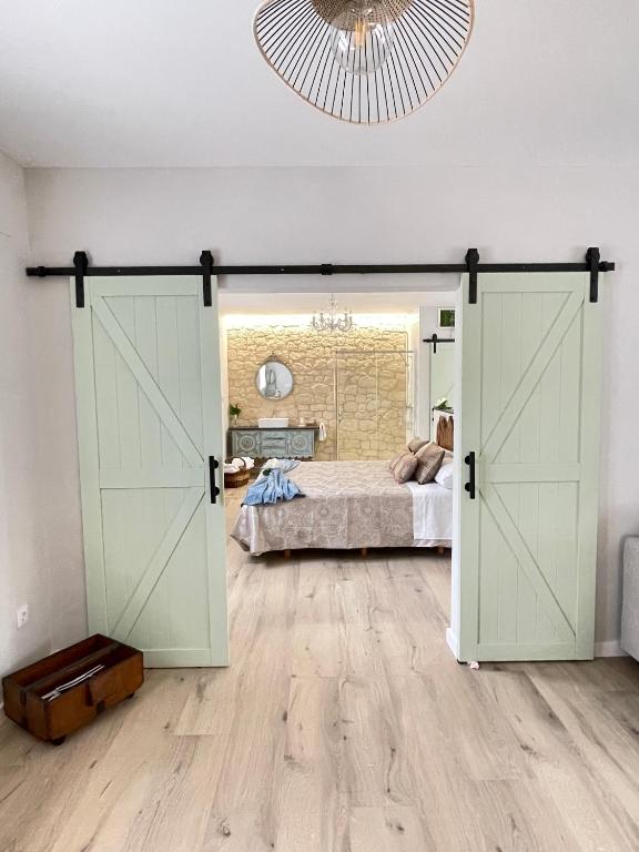 an open barn door in a bedroom with a bed at Apartamentos LA SOMERA in Alhama de Aragón