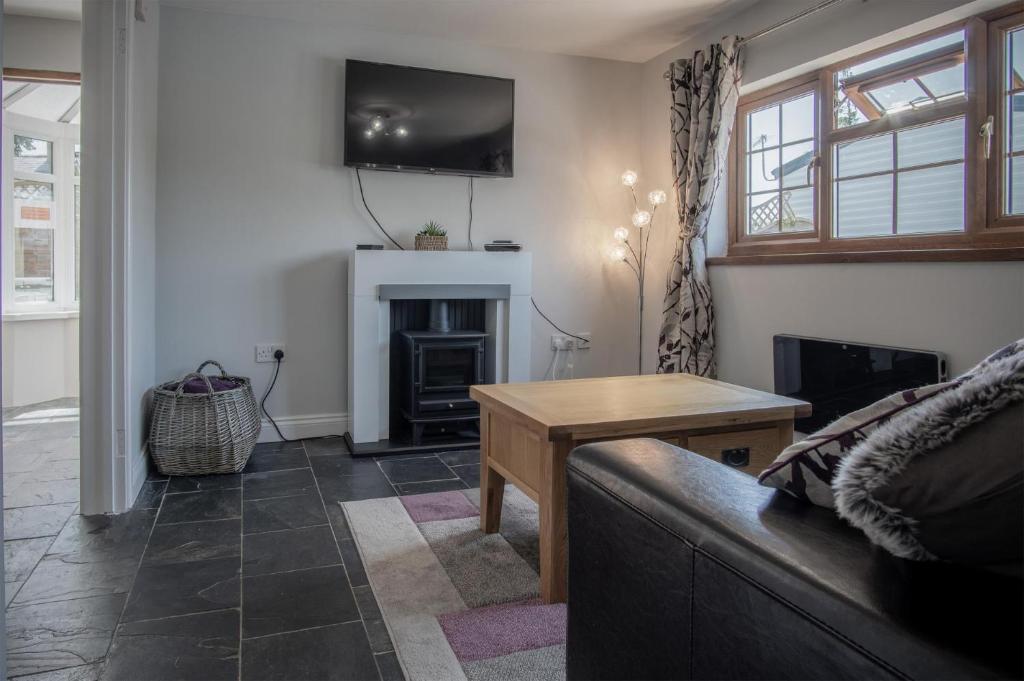 a living room with a couch and a fireplace at Lilac Cottage - 1 Bedroom Cottage - Amroth in Amroth