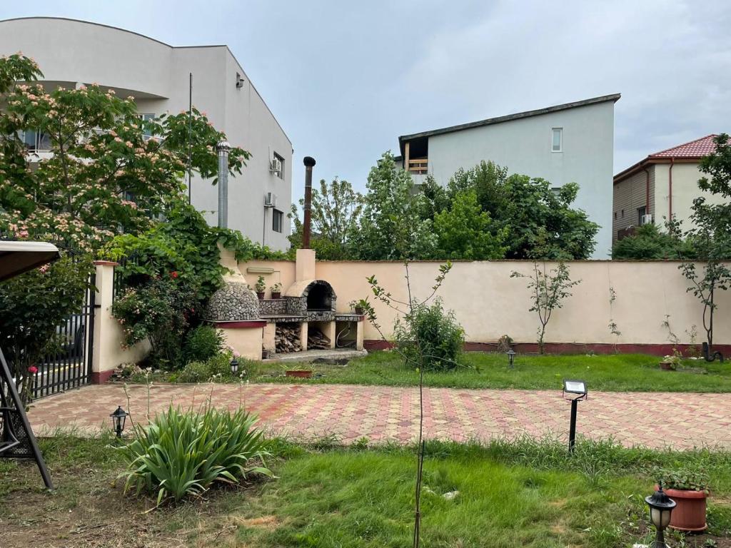 un jardin en face d'un bâtiment blanc dans l'établissement Vila Nadia, à Eforie Nord