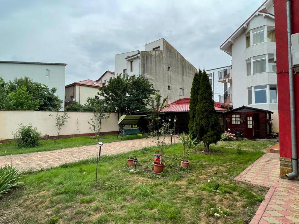 einen Hof mit Topfpflanzen und ein Gebäude in der Unterkunft Vila Nadia in Eforie Nord