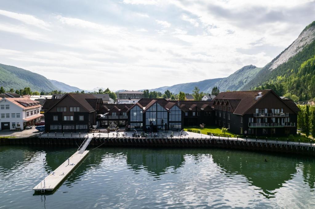 a town on the water with mountains in the background at Rognan Hotel in Rognan
