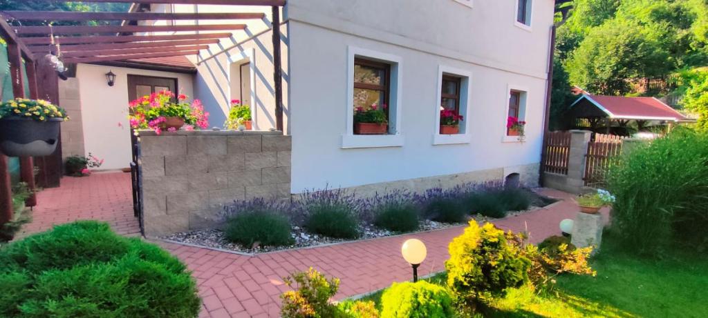 dom z ogrodem z kwiatami na dziedzińcu w obiekcie Wellness apartmán Bělá w mieście Děčín