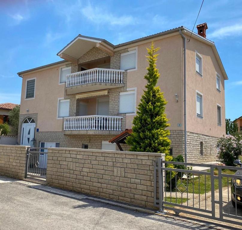 a house with a fence in front of it at Apartments Ban in Galižana