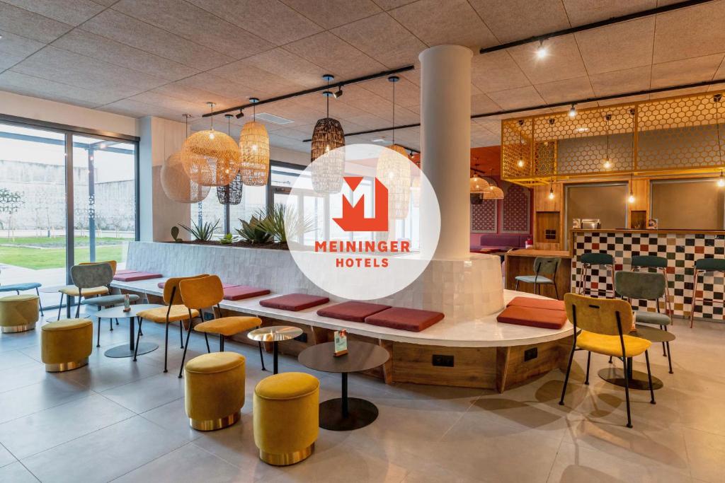 a restaurant with tables, chairs, and tables in it at Meininger Marseille Centre la Joliette in Marseille
