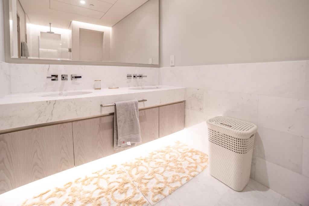 a bathroom with a sink and a mirror and a rug at Palm Tower Palm Jumeirah Dubai in Dubai