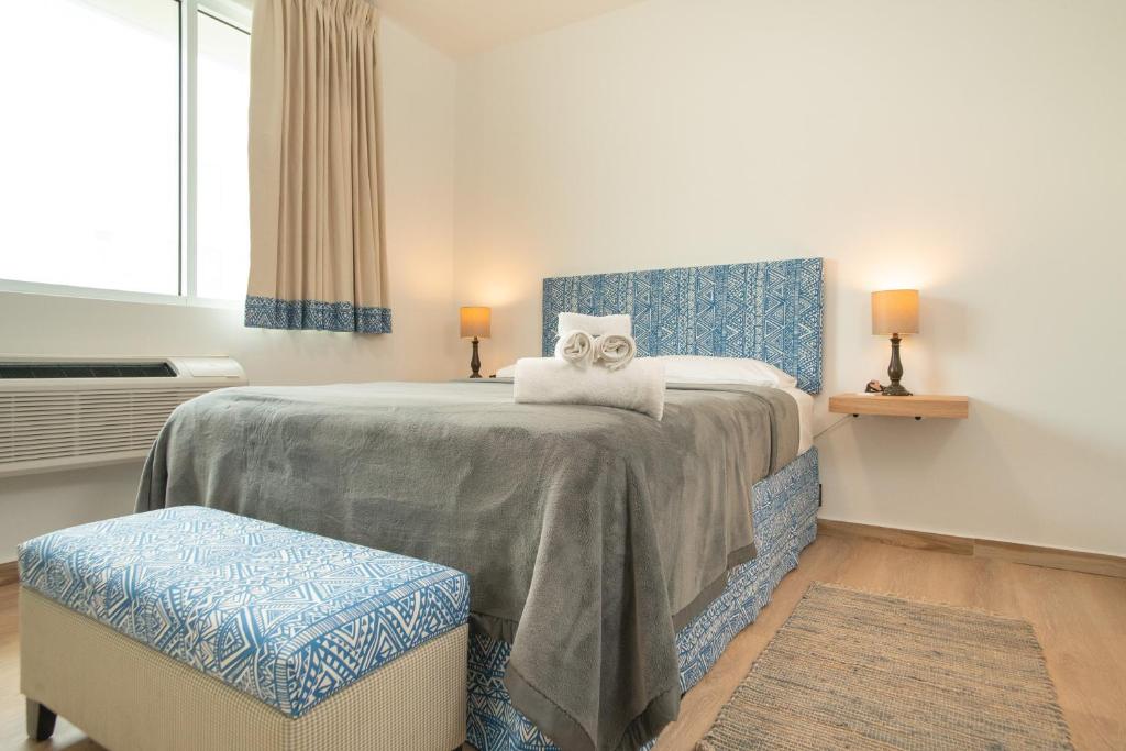 a bedroom with a large bed with two ottomans at Casa Condado Hotel in San Juan