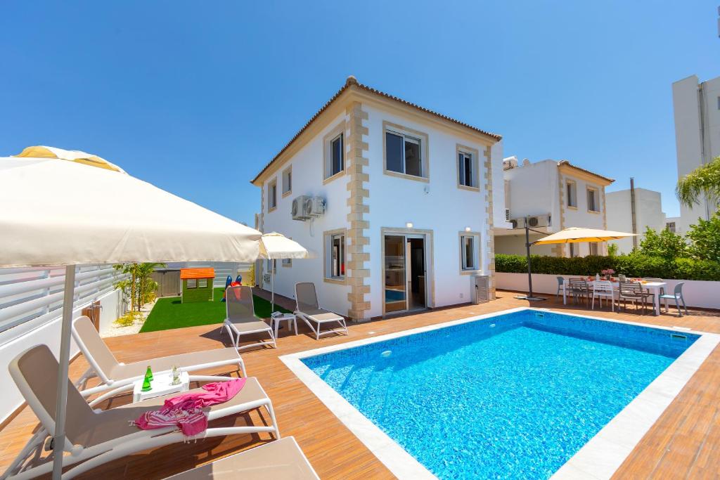 a villa with a swimming pool and a house at Villa Lantos Central Protaras in Protaras