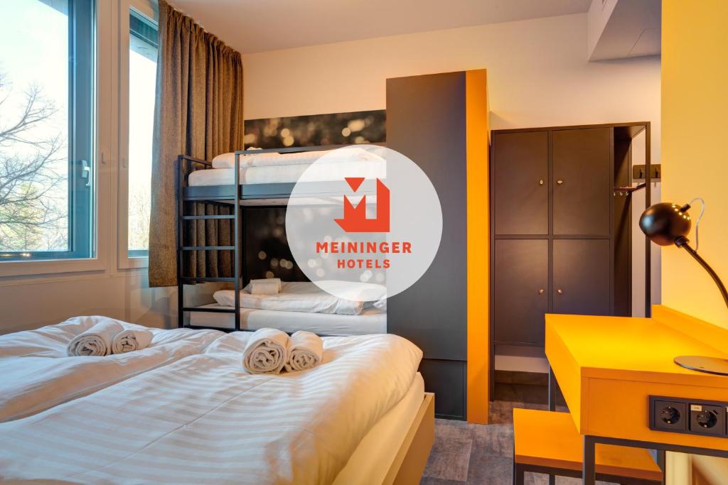 MEININGER Hotel München Olympiapark في ميونخ: سريرين في غرفة مكتوب عليها اسلوب الفنادق