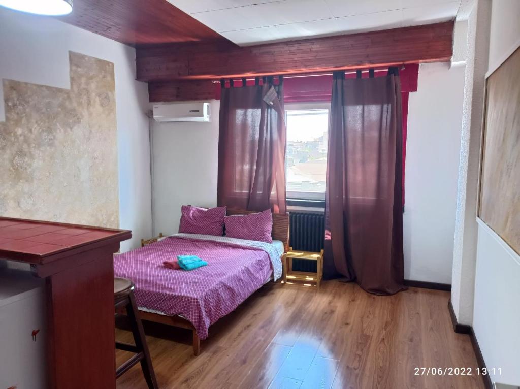 a small bedroom with a pink bed and a window at Sweet central apartment in Bucharest