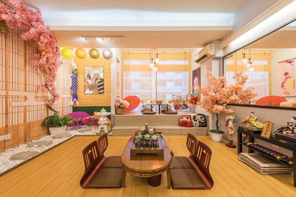 a living room with a table and chairs and flowers at Ancient Loft House -Japan Theme KL Bukit Bintang in Kuala Lumpur