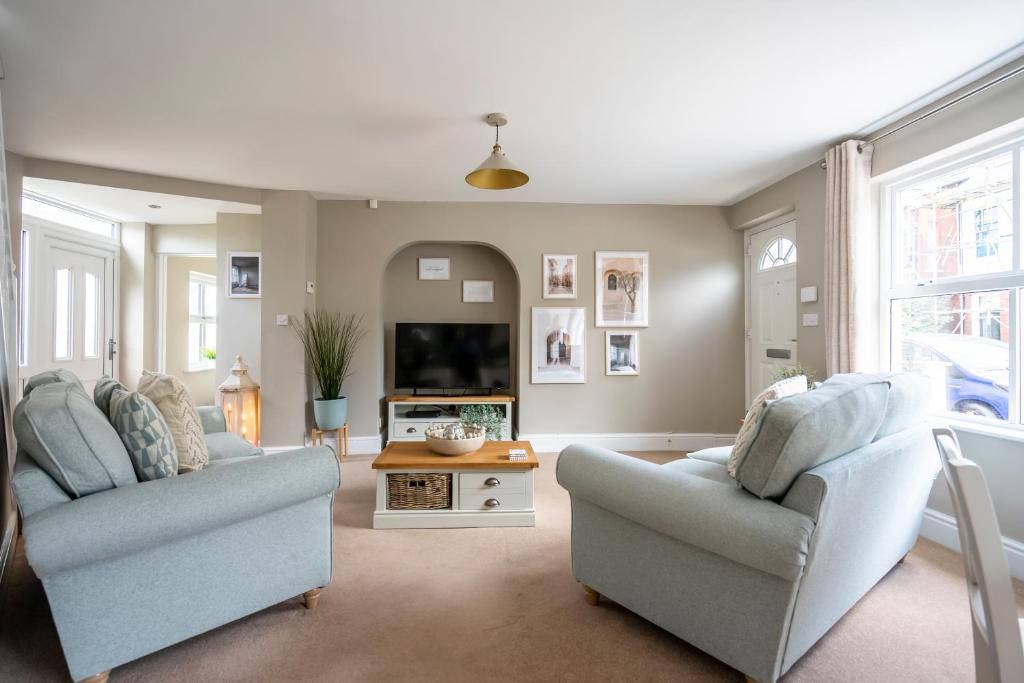 a living room with two chairs and a tv at Southbank Cottage in York