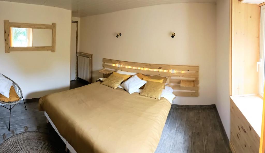 una camera con un grande letto con testiera in legno di Domaine Minio Bihan a Pluvigner