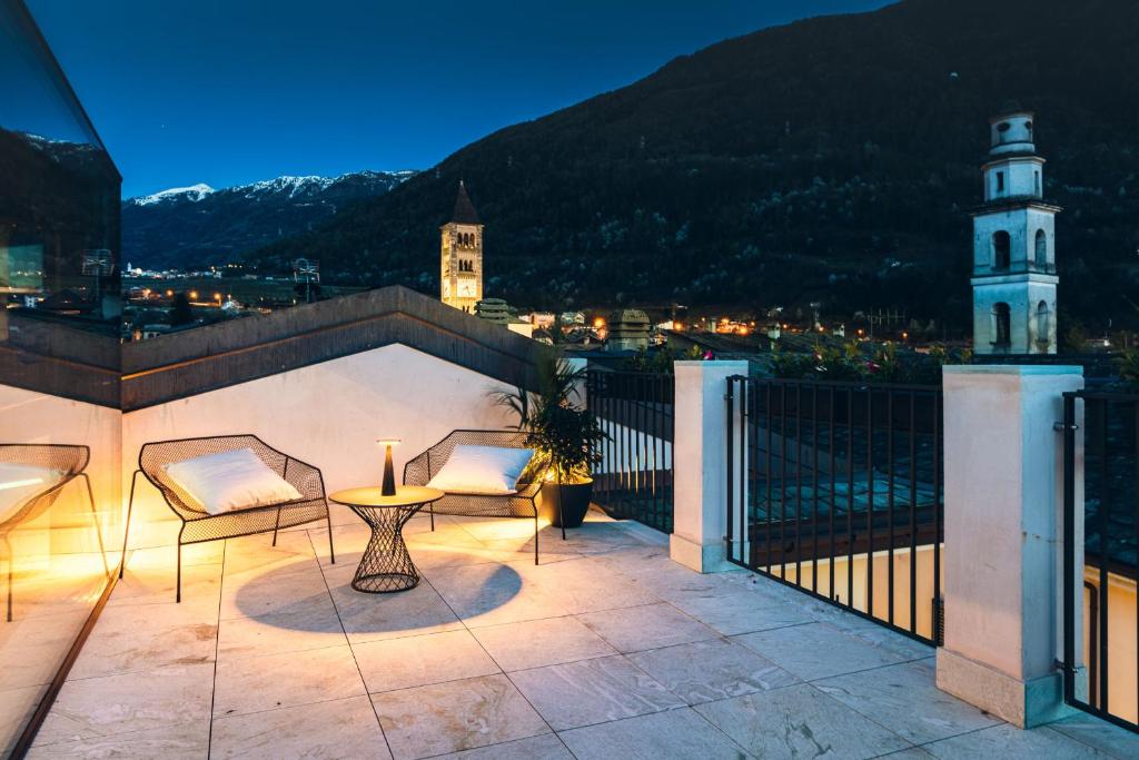 a patio with a table and chairs on a balcony at DOMUS CAVOUR Rooms&Suites in Tirano
