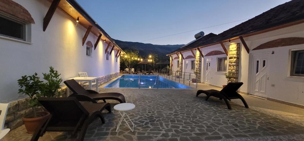 a patio with chairs and a pool in a house at Guesthouse Lord Byron in Tepelenë