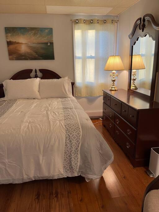 um quarto com uma cama, uma cómoda e um espelho em My Cozy Apartment Cottage em Grande-Digue