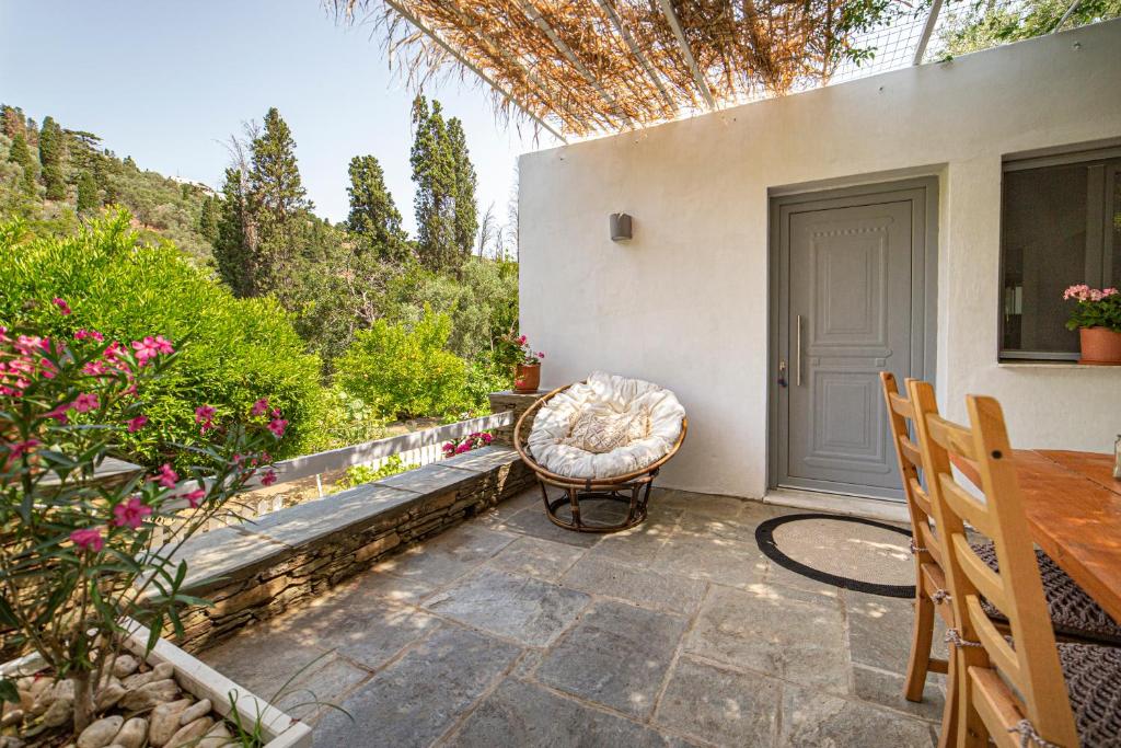 a patio with a chair and a table and a door at Small Paradise in Andros