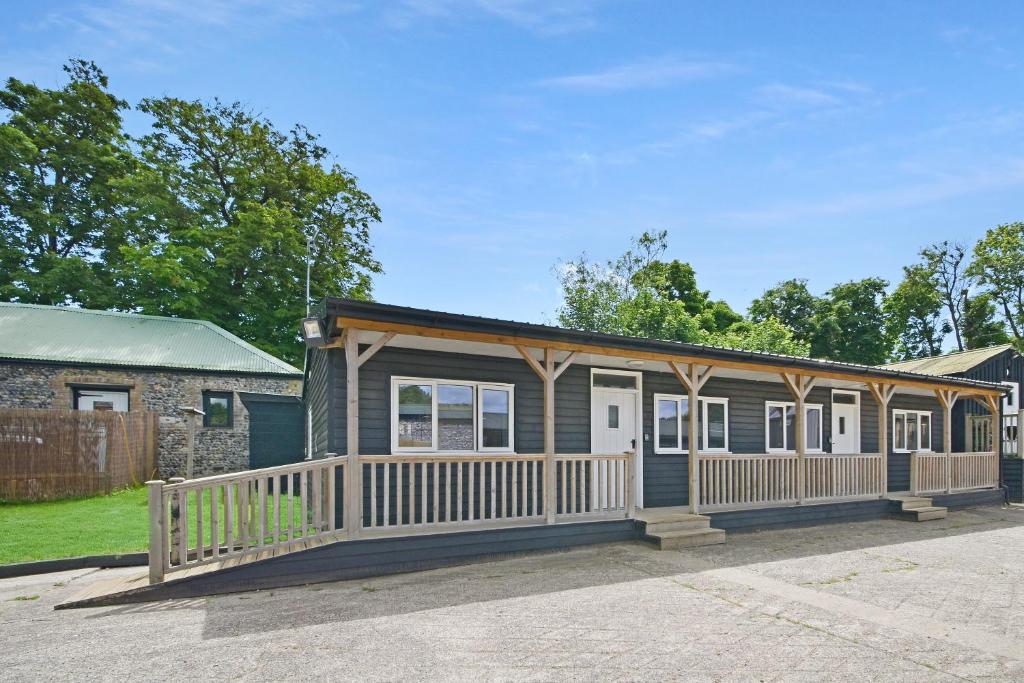 a house with a porch and a fence at The Cow Shed at Quex Park Estate in Birchington