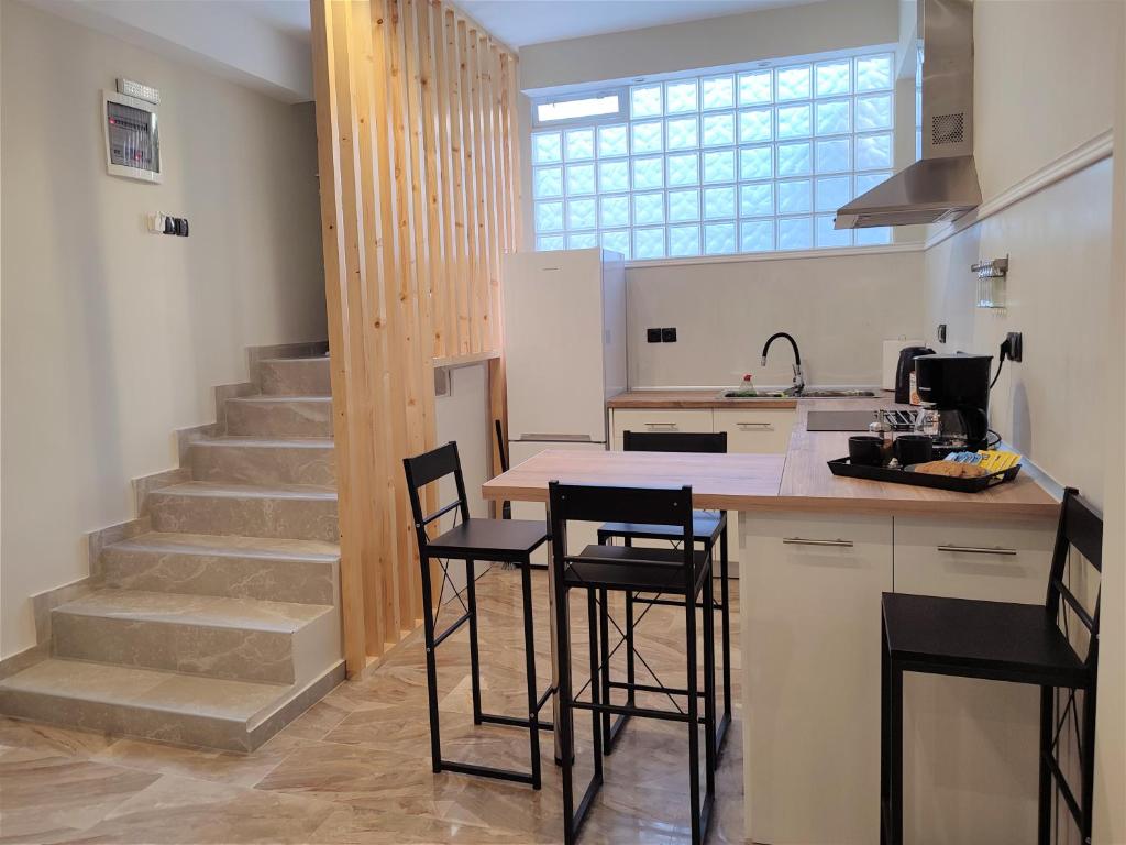 a kitchen with a counter with stools and a sink at I&G Studios, Nafplio in Nafplio
