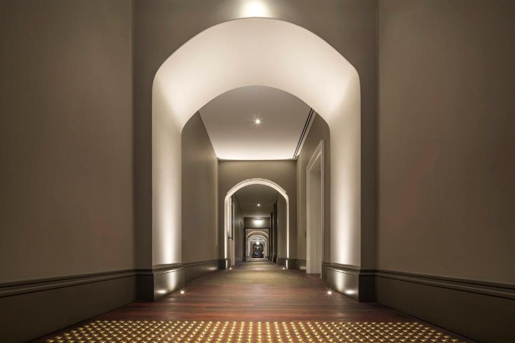 an empty corridor with an archway in a building at COMO The Treasury in Perth