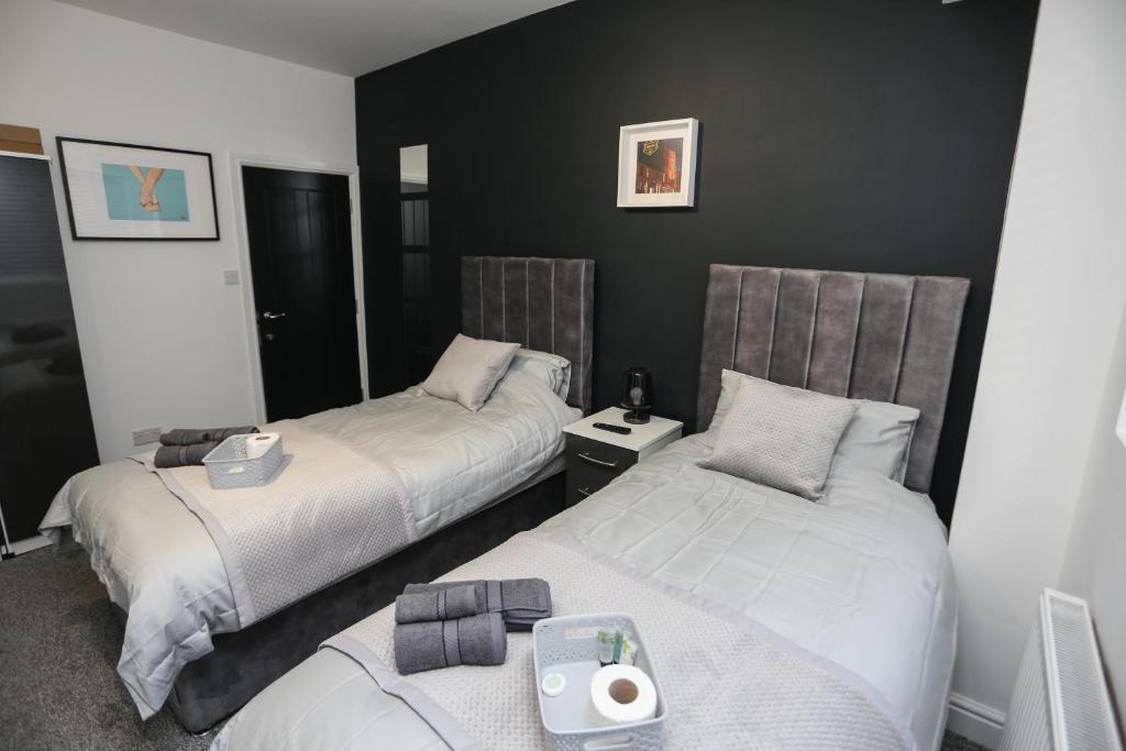 two beds in a room with black walls at Cheerful 4-bedroom home in Sheffield in Walkley