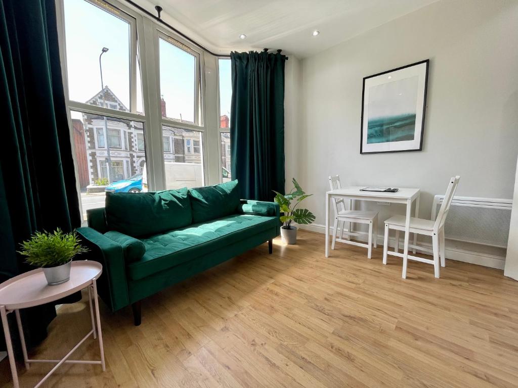 - un salon avec un canapé vert et une table dans l'établissement 1 Bed 2 Person Apartment City Centre, à Cardiff
