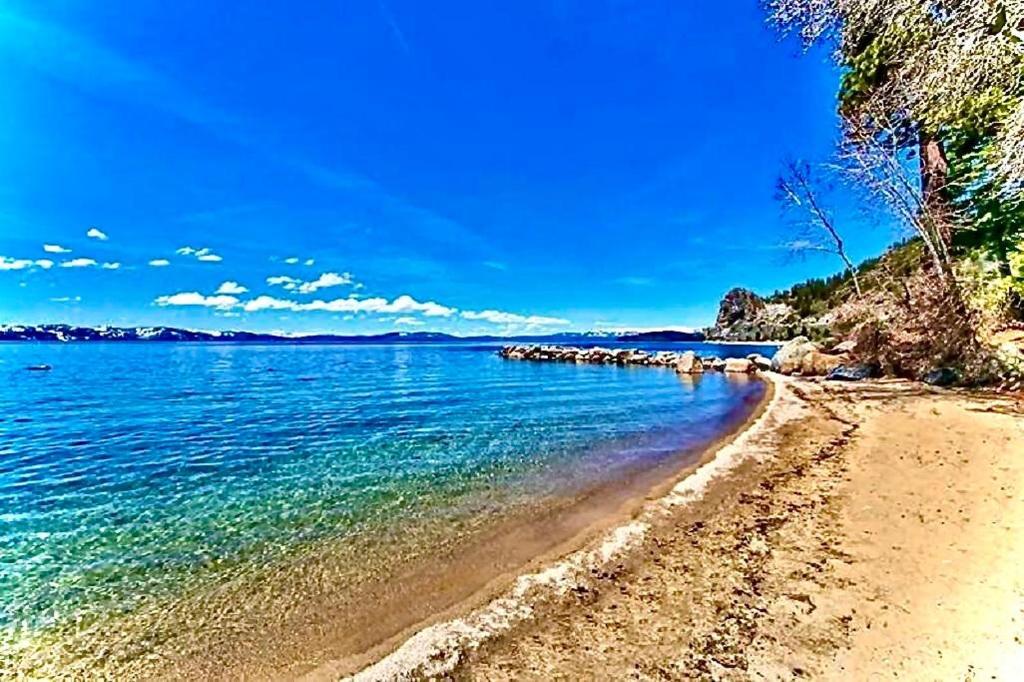 a beach with blue water and a blue sky at LUXE 4 Blue Diamond Lake Tahoe Lodge in Stateline