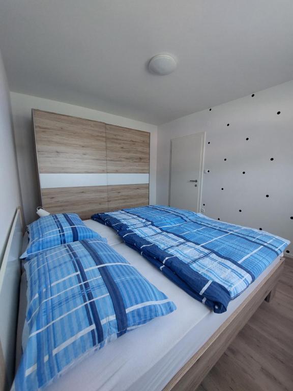 a bedroom with a bed with blue and white pillows at Apartments Marica in Kranjska Gora