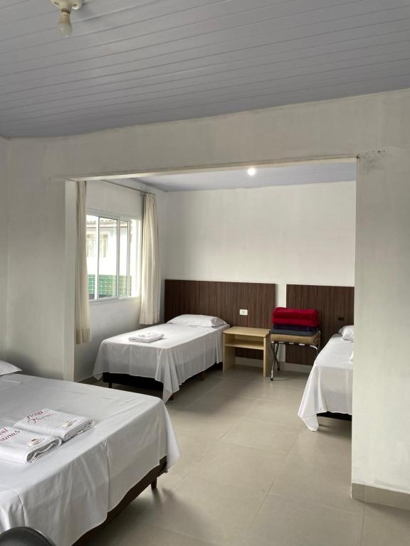 Habitación de hotel con 2 camas y espejo en Hotel Nunes, en Curitiba