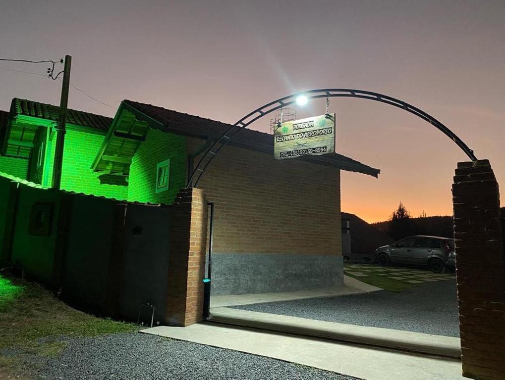 een groen gebouw met een straatlicht erop bij Pousada Recanto do Aeroporto in Monte Verde