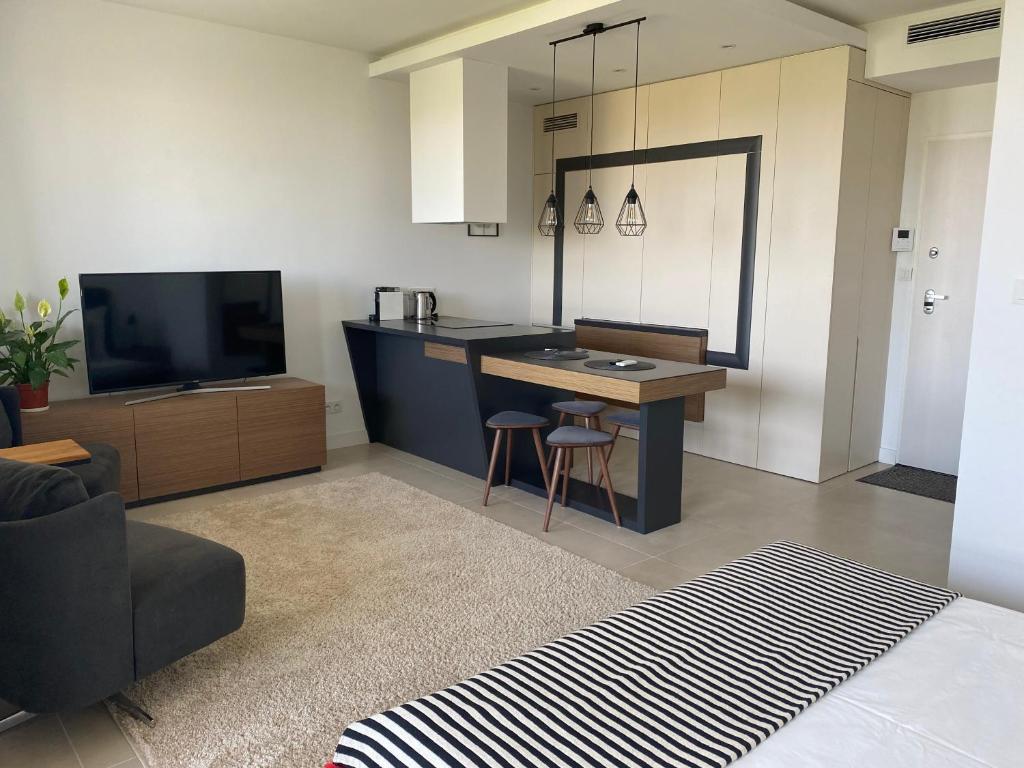 salon z kuchnią ze stołem i telewizorem w obiekcie LuxLux Apartments Sand w Warszawie