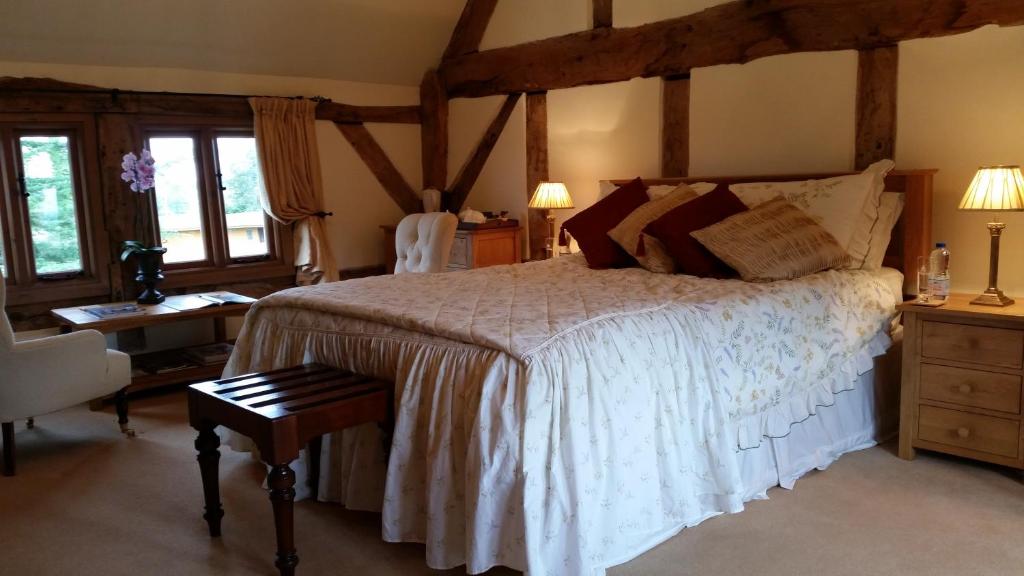 a bedroom with a bed and a desk and windows at Ty Derw Country House B&B in Ruthin