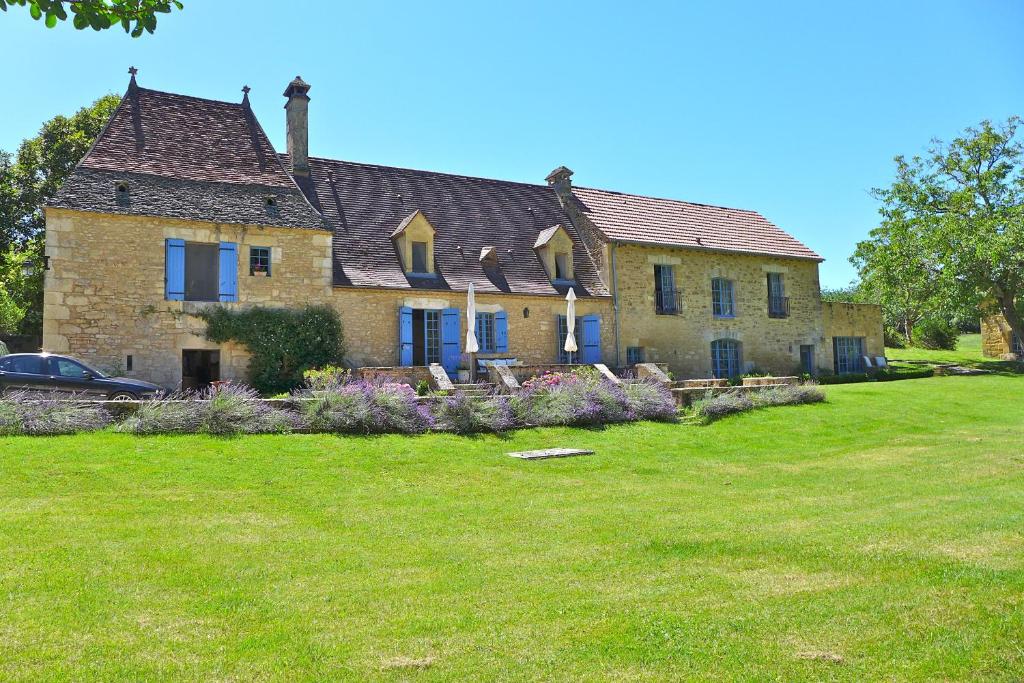 a large house with a yard in front of it at Par La Rivière in La Roque-Gageac