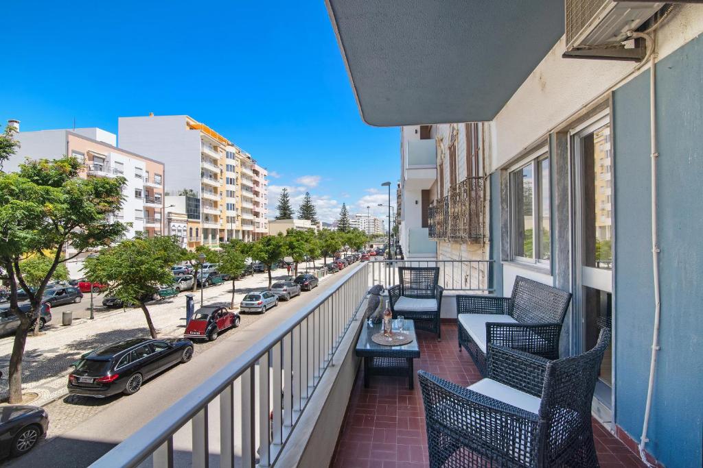 a balcony with chairs and a view of a street at Brisa do Sul in Olhão