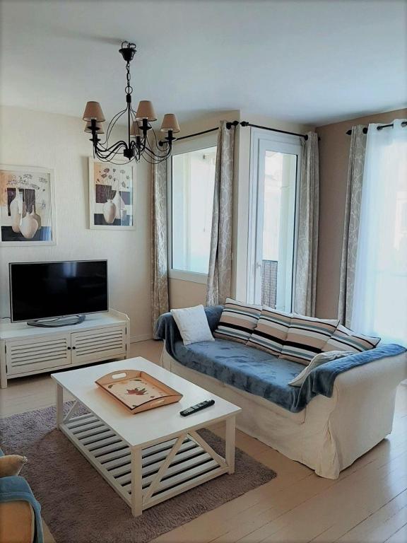 un salon avec un canapé et une table dans l'établissement Appt cosy 65 m2 coeur de ville à 150 m de la plage, à Royan