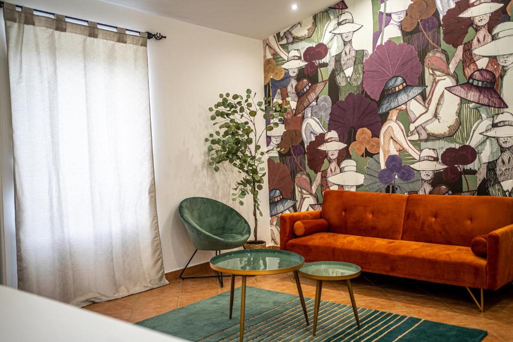a living room with a couch and a floral wall at Vicolo delle Forbici in Città della Pieve