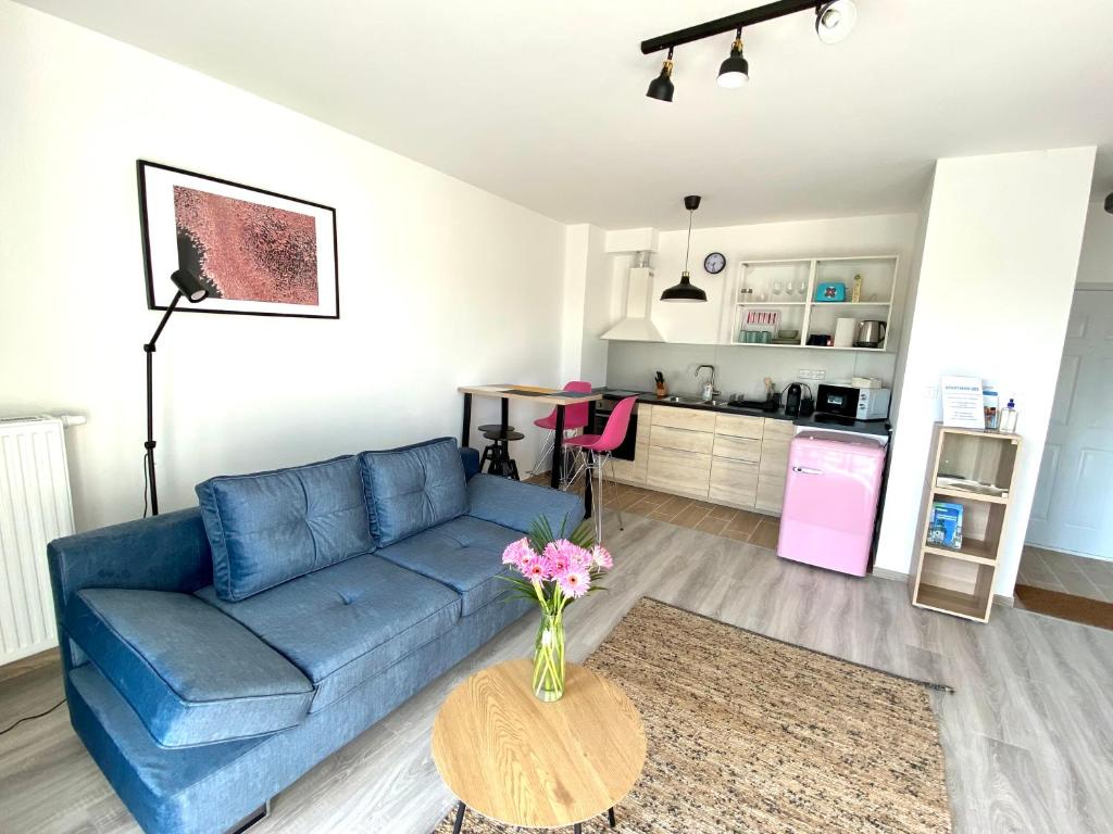 ein Wohnzimmer mit einem blauen Sofa und einem Tisch in der Unterkunft Apartman 001 in Bük