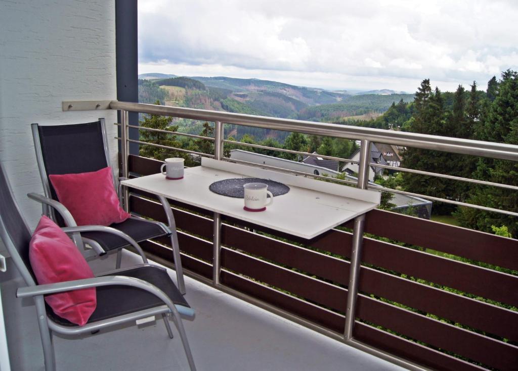 einen Balkon mit 2 Stühlen, einem Tisch und Aussicht in der Unterkunft Winterberg Appartement 21093 in Winterberg