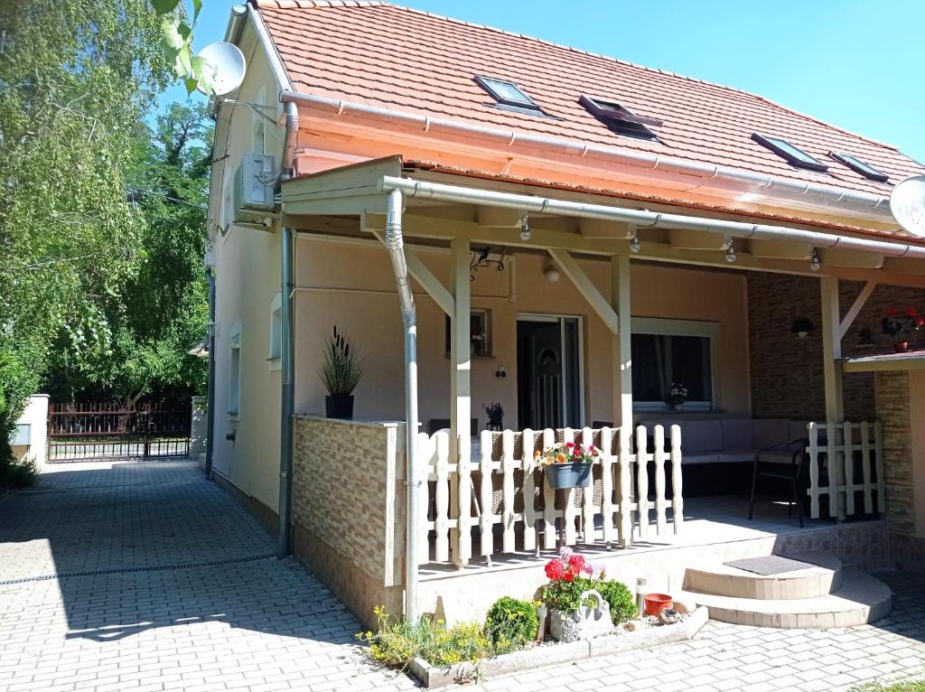 uma casa com um telhado laranja e uma cerca branca em Sommer Ferienhaus em Balatonszárszó