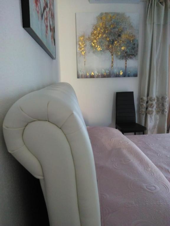 a bed with a white chair in a bedroom at Sos Manneddos in Posada