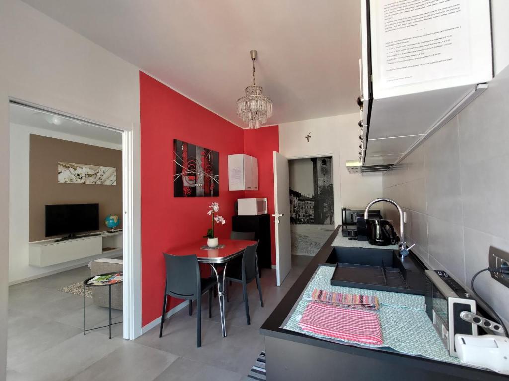 uma cozinha com uma parede em tons de vermelho e uma mesa em Design apartment n. 41 em Trento