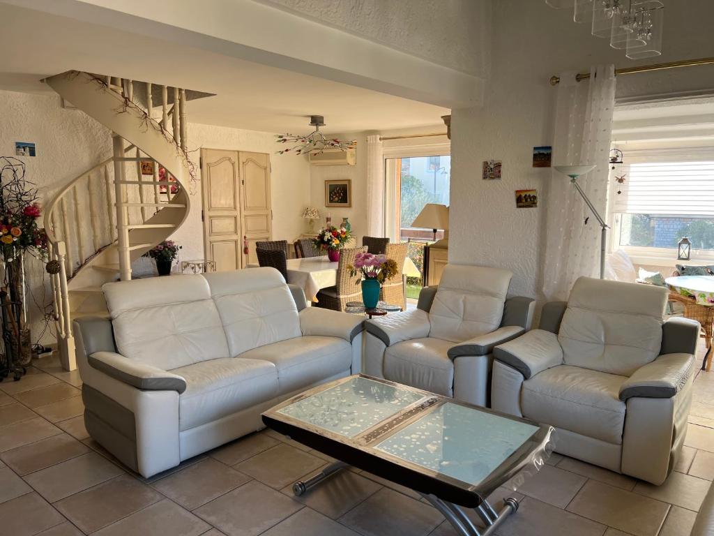 ein Wohnzimmer mit Sofas und einem Couchtisch in der Unterkunft Haut de villa très bien équipé avec jardin, piscine, proche centre ville Sanary in Sanary-sur-Mer