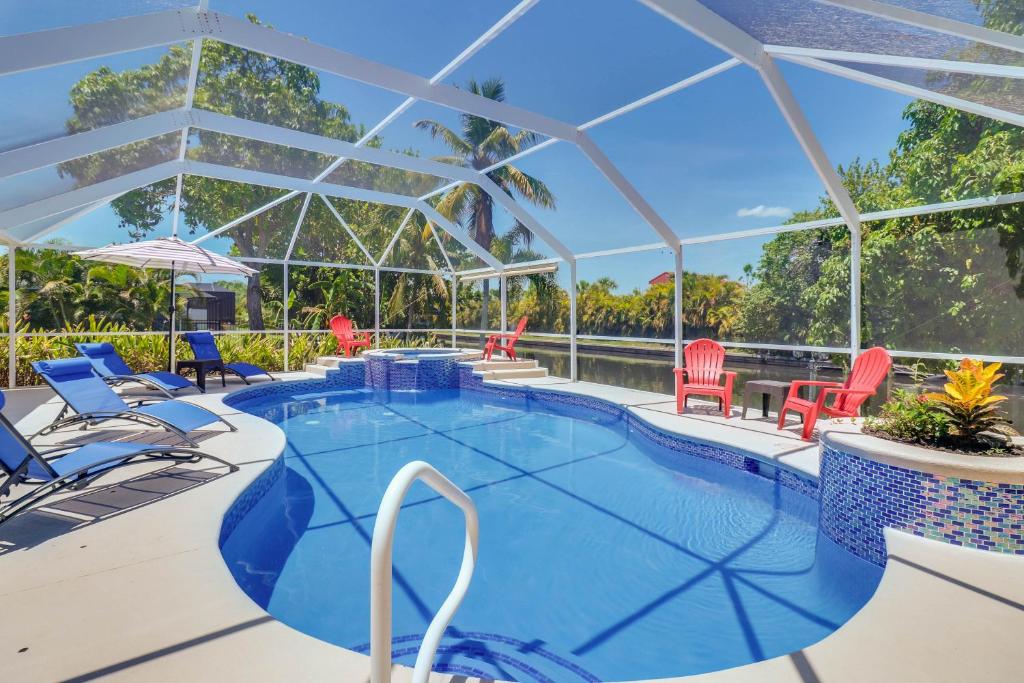 a large swimming pool with chairs at Waterfront Pool Villa with Sailboat access in Cape Coral